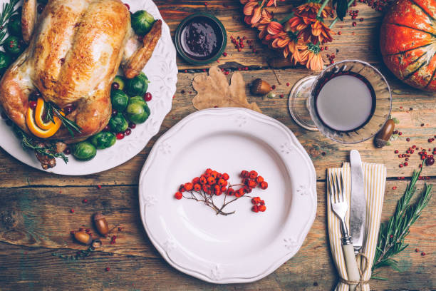 istock Thanksgiving roasted chicken with Brussels sprouts and spices on a rustic wooden table. Thanksgiving dinner or fall dinner concept background with autumn leaves. Thanksgiving table setting background. 1074213274