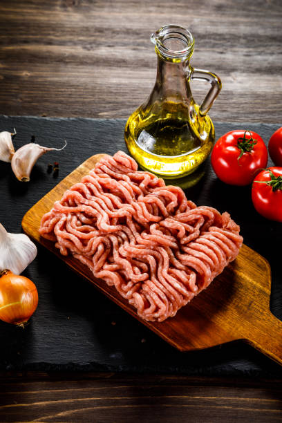 istock Raw minced meat, vegetables and seasonings on stone background 1074222068