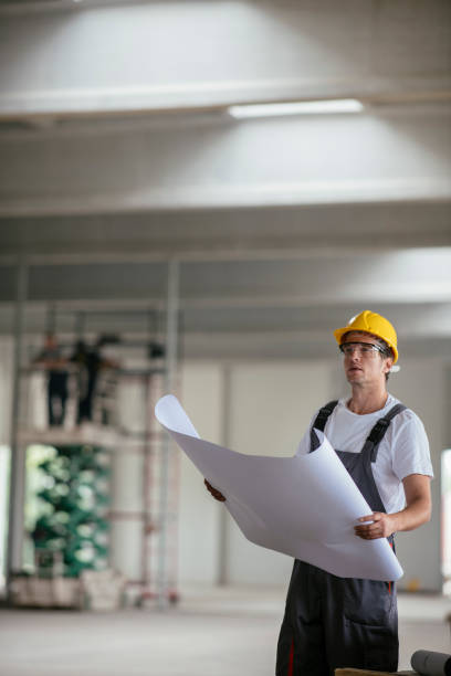 istock Handsome engineer in factory with blueprint 1074223264