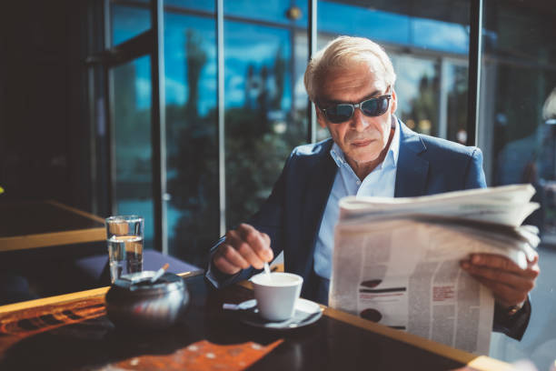 istock Businessman at coffee break reading a newspaper 1074227864