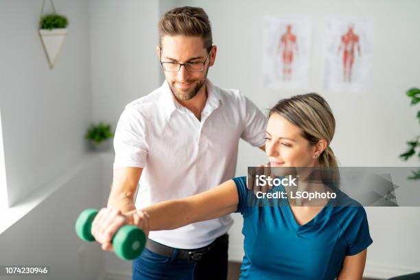 A Modern Rehabilitation Physiotherapy Man At Work With Woman Client Stock Photo - Download Image Now