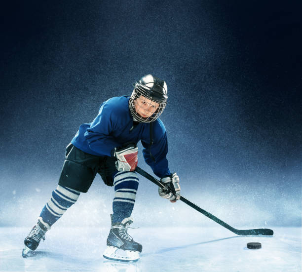 istock Little boy playing ice hockey 1074231354