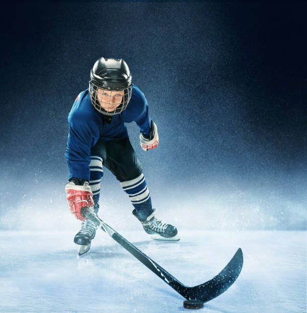 istock Little boy playing ice hockey 1074231358