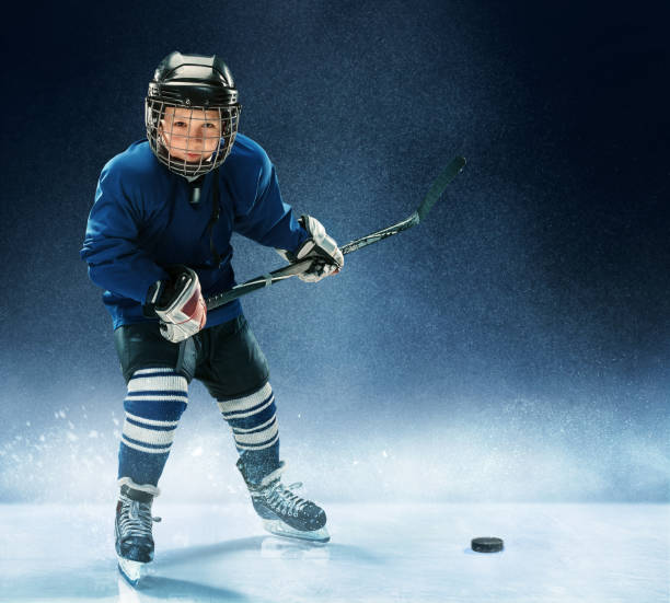 istock Little boy playing ice hockey 1074231360