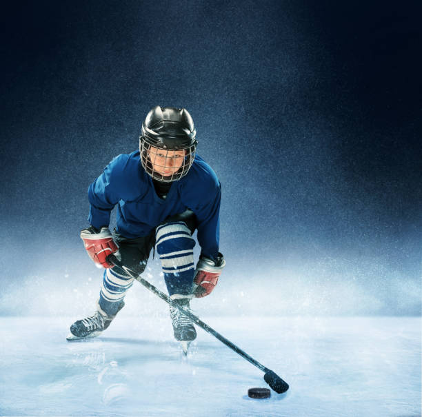 istock Little boy playing ice hockey 1074231366