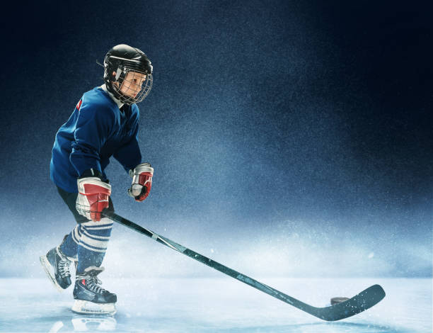istock Little boy playing ice hockey 1074231368