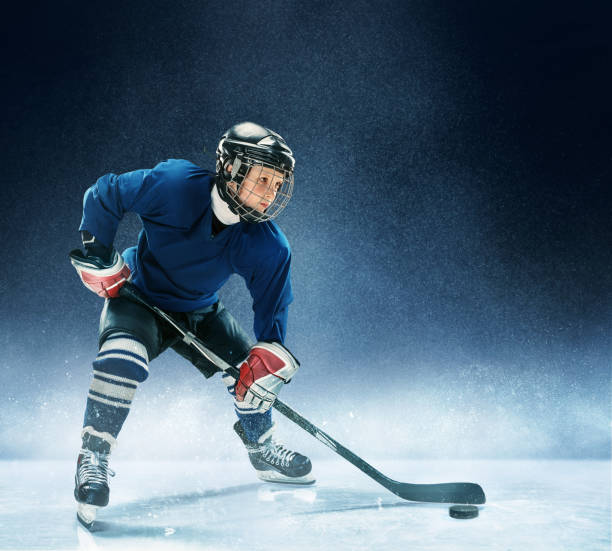 istock Little boy playing ice hockey 1074231392