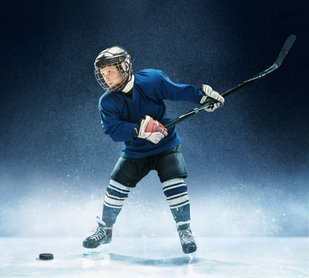 istock Little boy playing ice hockey 1074231394