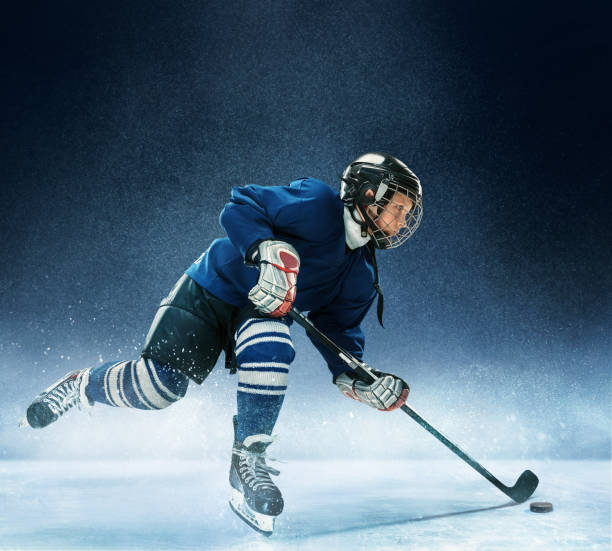 kleiner junge eishockey zu spielen - winter sport team sport hockey puck sport stock-fotos und bilder