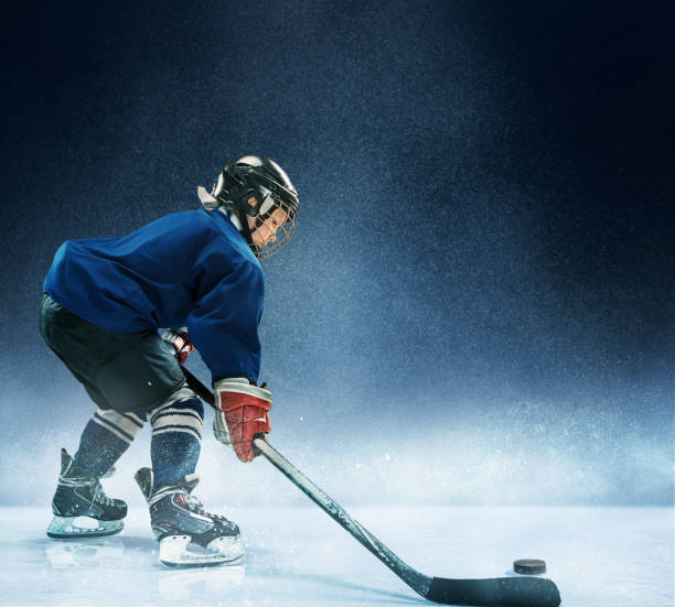 istock Little boy playing ice hockey 1074231412