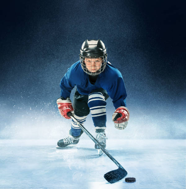 istock Little boy playing ice hockey 1074231424