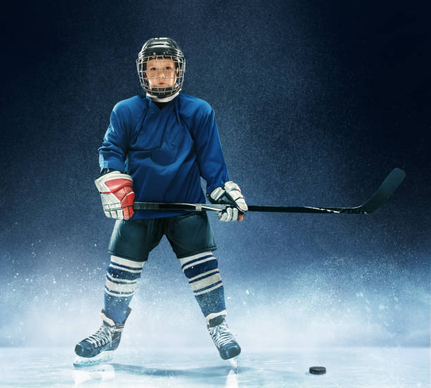 istock Little boy playing ice hockey 1074231428