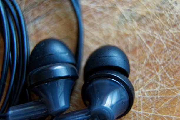 istock Close-up headphone stack on table, modern smartphone's earbuds device accessories 1074235116