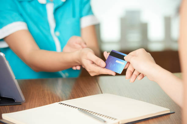 istock Guest giving card to spa salon administrator 1074238366