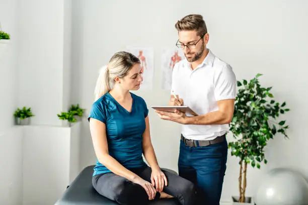 Photo of A Modern rehabilitation physiotherapy man at work with woman client