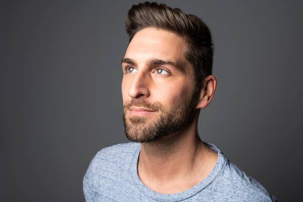 istock A Handsome man standing over dark grey background Portrait man concept. 1074239372