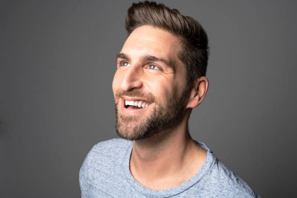 istock A Handsome man standing over dark grey background Portrait man concept. 1074239428