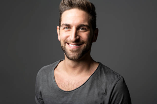 istock A Handsome man standing over dark grey background Portrait man concept. 1074239826