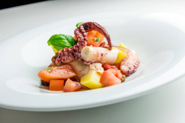 istock Dish with salad of octopus potatoes capers tomato and basil 1074242216