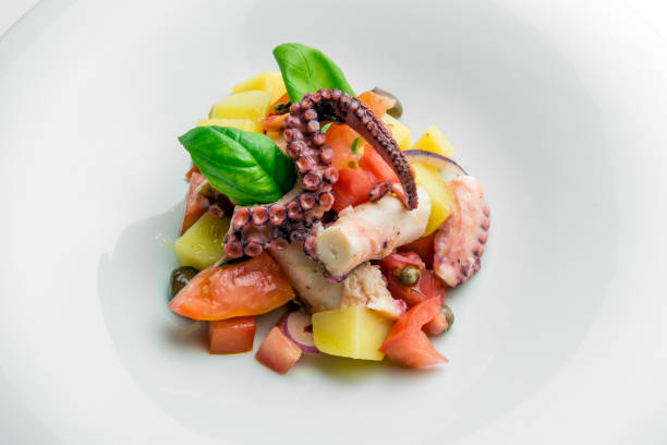 istock Dish with salad of octopus potatoes capers tomato and basil 1074242300
