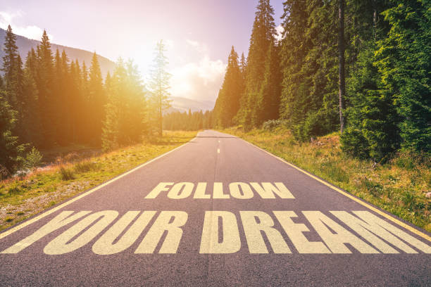 istock Follow your dream text written on road in the mountains 1074245434