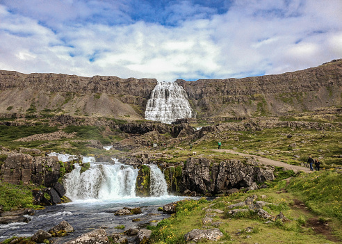 Stunning view on Dynjandi : series of waterfalls located in the Westfjords, Iceland. Popular tourist destination in sunny day with blue sky