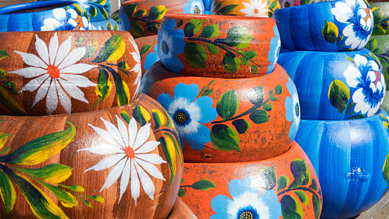 Close up on sets of colorful hand painted Mexican ceramic pots, traditional pottery found at a market stall in Old Town, a state historic park in San Diego, California, USA