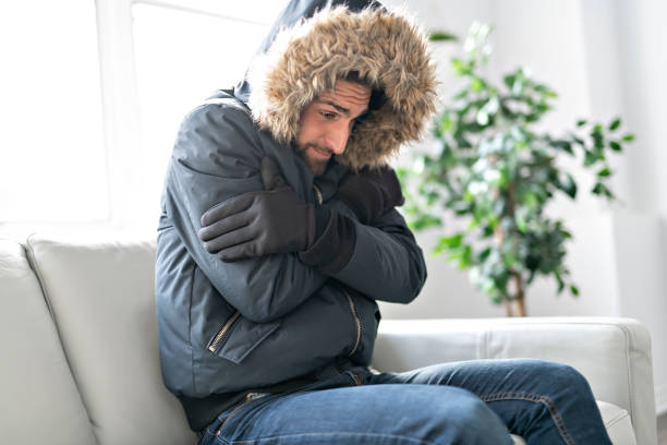 istock A Man have cold on the sofa at home with winter coat 1074250668
