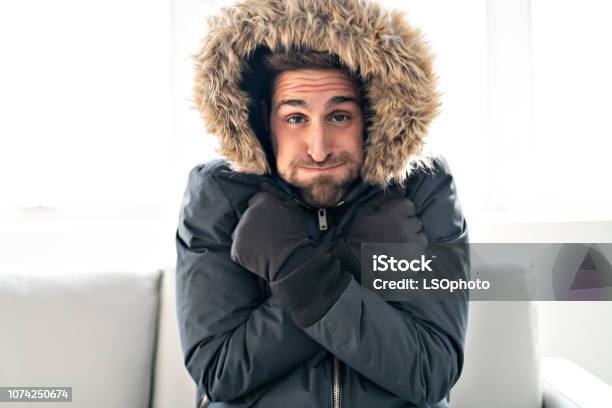 A Man Have Cold On The Sofa At Home With Winter Coat Stock Photo - Download Image Now