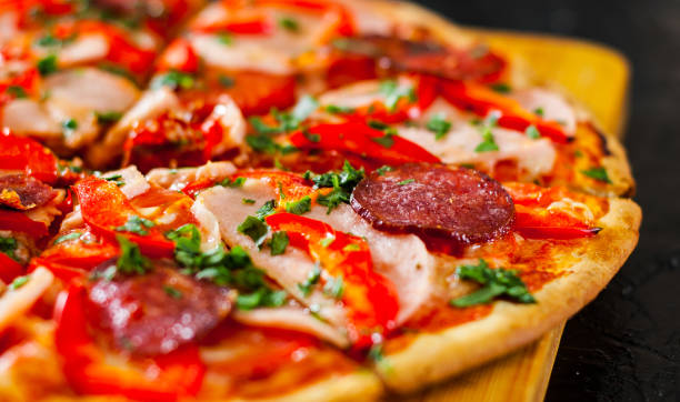 istock Pizza with Mozzarella cheese, Ham, Tomatoes, salami, pepper, pepperoni Spices and Fresh Basil. Italian pizza 1074251852