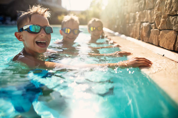 istock Kids playing in swimming pool 1074254192