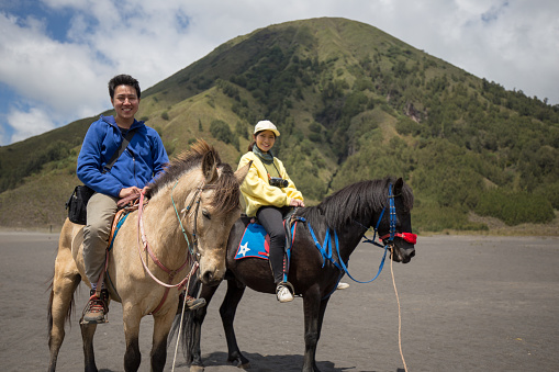 Traveler couple ride a horse at Mt. Bromo, east Java, Indonesia.
