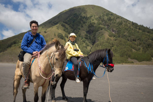 путешественник пара ездить на лошади на горе бромо, восточная ява, индонезия. - bromo crater стоковые фото и изображения