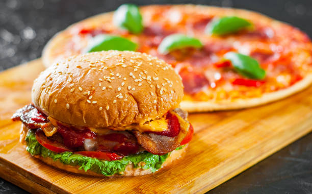 Hamburger au fromage bacon avec de bœuf patty tomate oignon et Pizza avec Mozzarella de fromage, de jambon, tomates, salami, poivrons, pepperoni épices et basilic frais - Photo