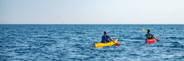 istock Kayakers rowing together in sea 1074257630