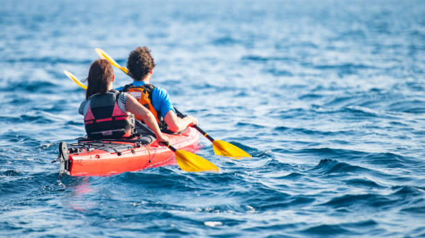 istock Kayakers rowing together in sea 1074257640