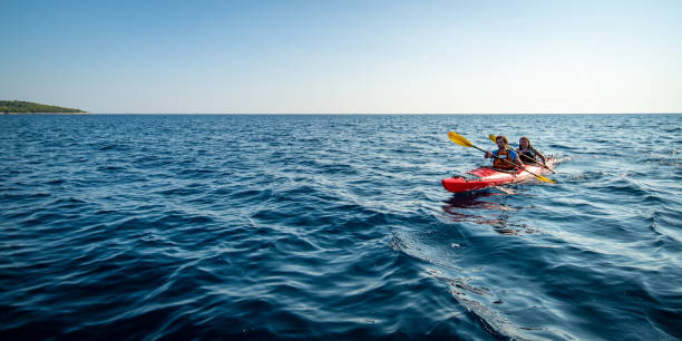 istock Kayakers rowing together in sea 1074257648