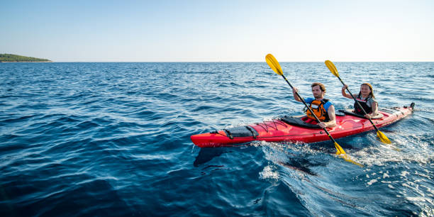kayakistes ramer ensemble en mer - canoe kayak, jaune photos et images de collection