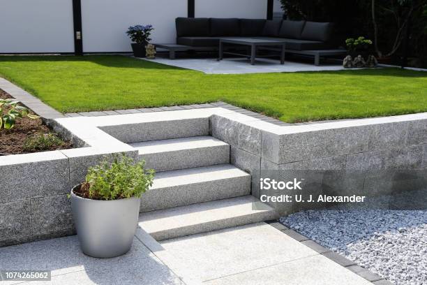 Neat And Tidy Garden With Granite Wall And Solid Block Steps Stock Photo - Download Image Now