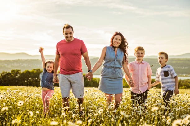istock Happy family having fun on daisy field at sunset 1074266256