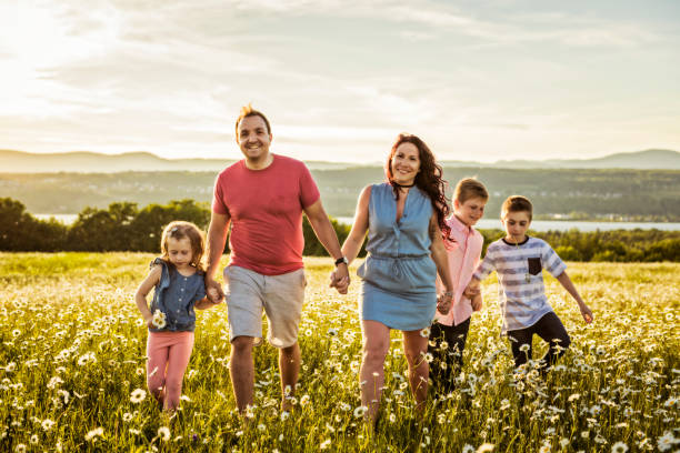 istock Happy family having fun on daisy field at sunset 1074266266