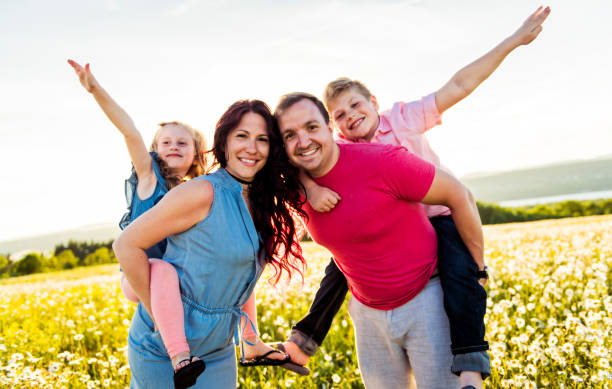 istock Happy family having fun on daisy field at sunset 1074266772