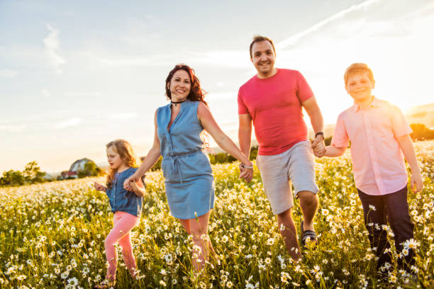 istock Happy family having fun on daisy field at sunset 1074267964