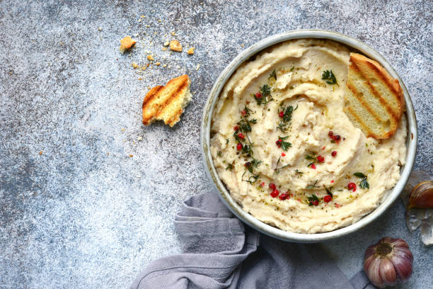 houmous de haricots blancs cuit ail et fines herbes séchées - greek cuisine greek culture food table photos et images de collection