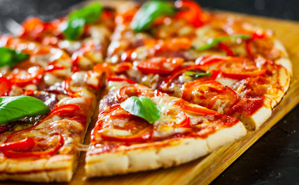 istock Pizza with Mozzarella cheese, Ham, Tomatoes, salami, pepper, pepperoni Spices and Fresh Basil. Italian pizza 1074272442
