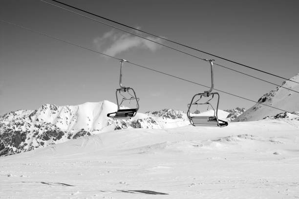 istock Black and white view on chair-lift and sunlight mountains 1074272534