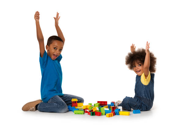 little african excited kids playing with lots of colorful plastic blocks indoor. isolated - african ethnicity brother ethnic little boys imagens e fotografias de stock