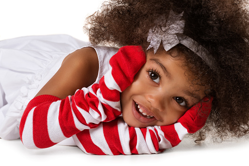 Portrait of a preschool child girl laying down. Studio shot. Isolated on white background