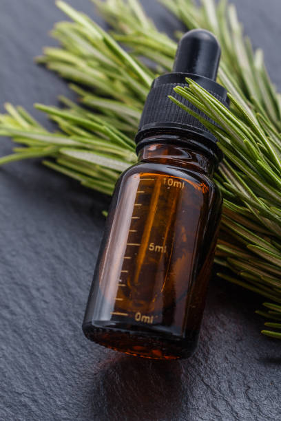 istock Rosemary essential oil on dark stone background 1074275674