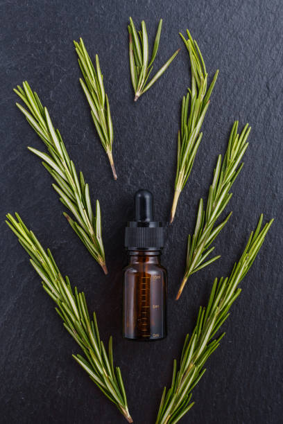istock Rosemary essential oil on dark stone background 1074276524